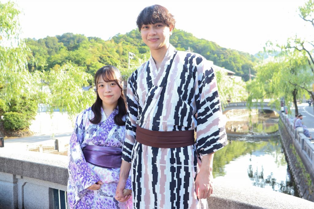 城崎温泉の柳並木沿いで浴衣姿の二人旅を楽しむお客様