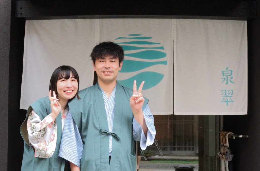 城崎温泉の旅館「泉翠」の玄関前で記念撮影をするカップルのお客様