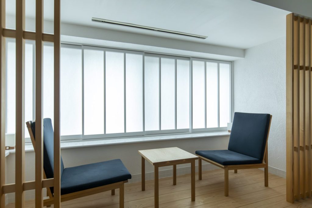 客室「上汐」の窓辺に置かれたhao & mei製作のテーブルと椅子。自然光に包まれながら穏やかな時間を過ごせる空間。