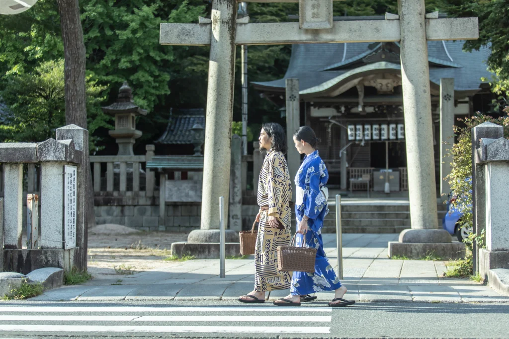 ゆかた姿で城崎温泉の温泉街を散策するご夫婦。新しい家族を迎える前の思い出づくりとして、ゆったりと街歩きを楽しむ様子。