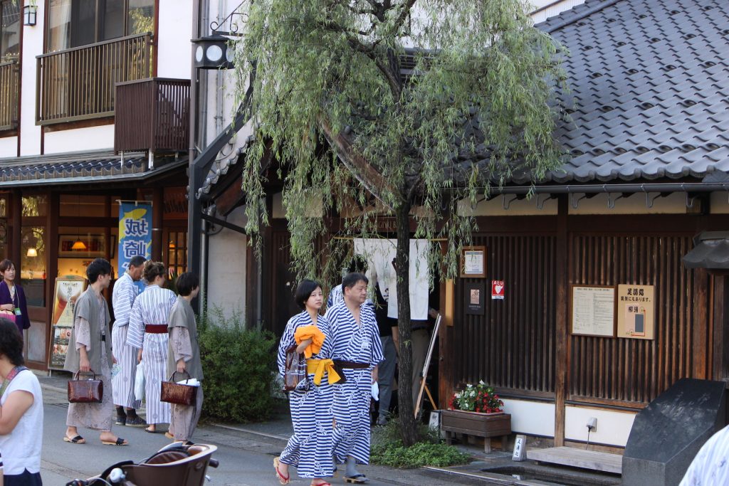 城崎温泉の外湯・柳湯の前を浴衣姿で歩く人々