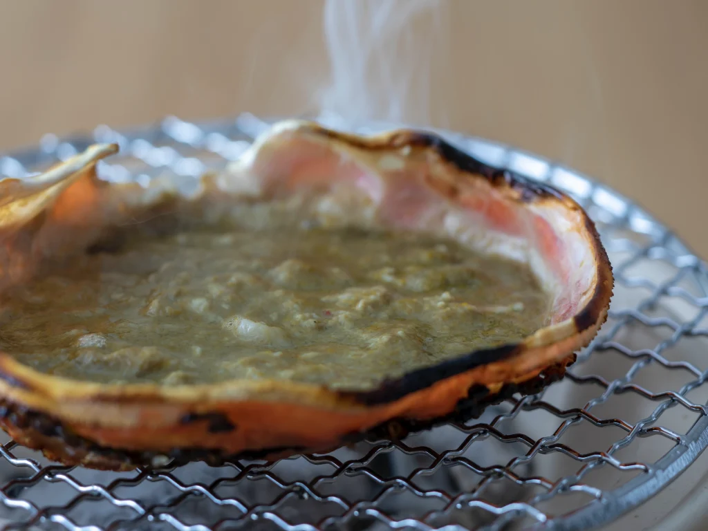 津居山蟹の蟹味噌を甲羅ごと焼き上げる様子