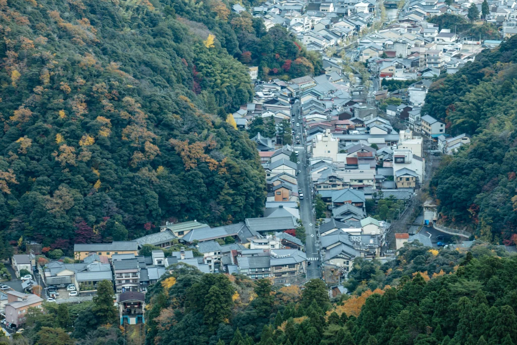 紅葉に囲まれた秋の城崎温泉を望む温泉街の風景