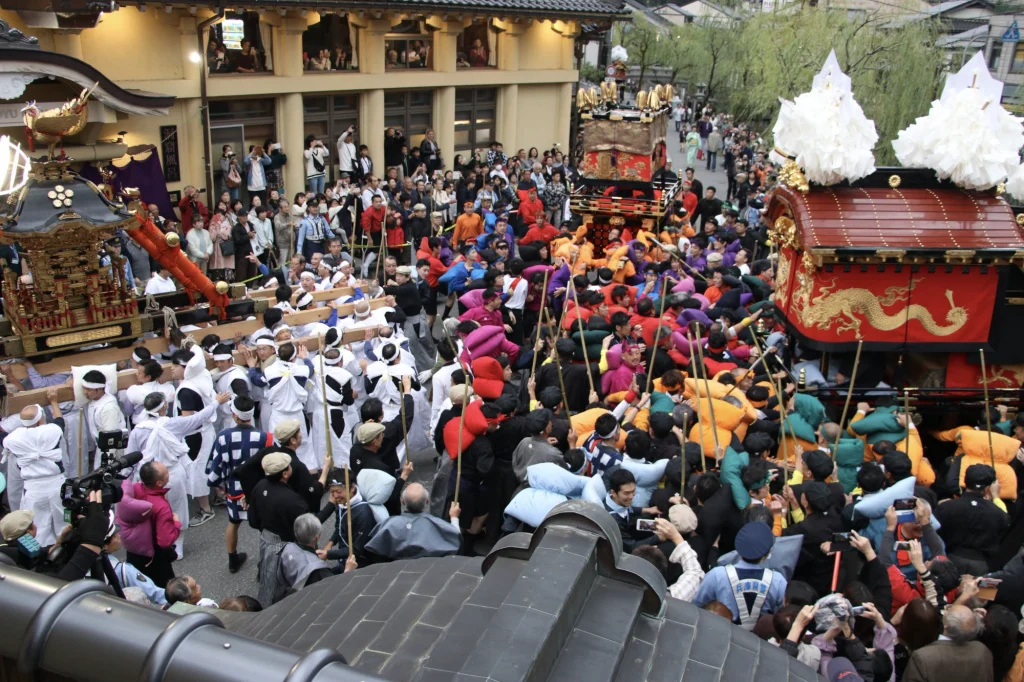 城崎秋祭りのセリで、神輿とだんじりが向き合い、上部・中部・下部の担ぎ手たちが競り合う様子