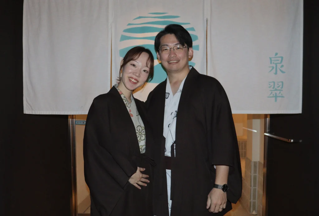 城崎温泉 泉翠の暖簾の前で、ゆかた姿で寄り添うマタニティ旅行中のご夫婦